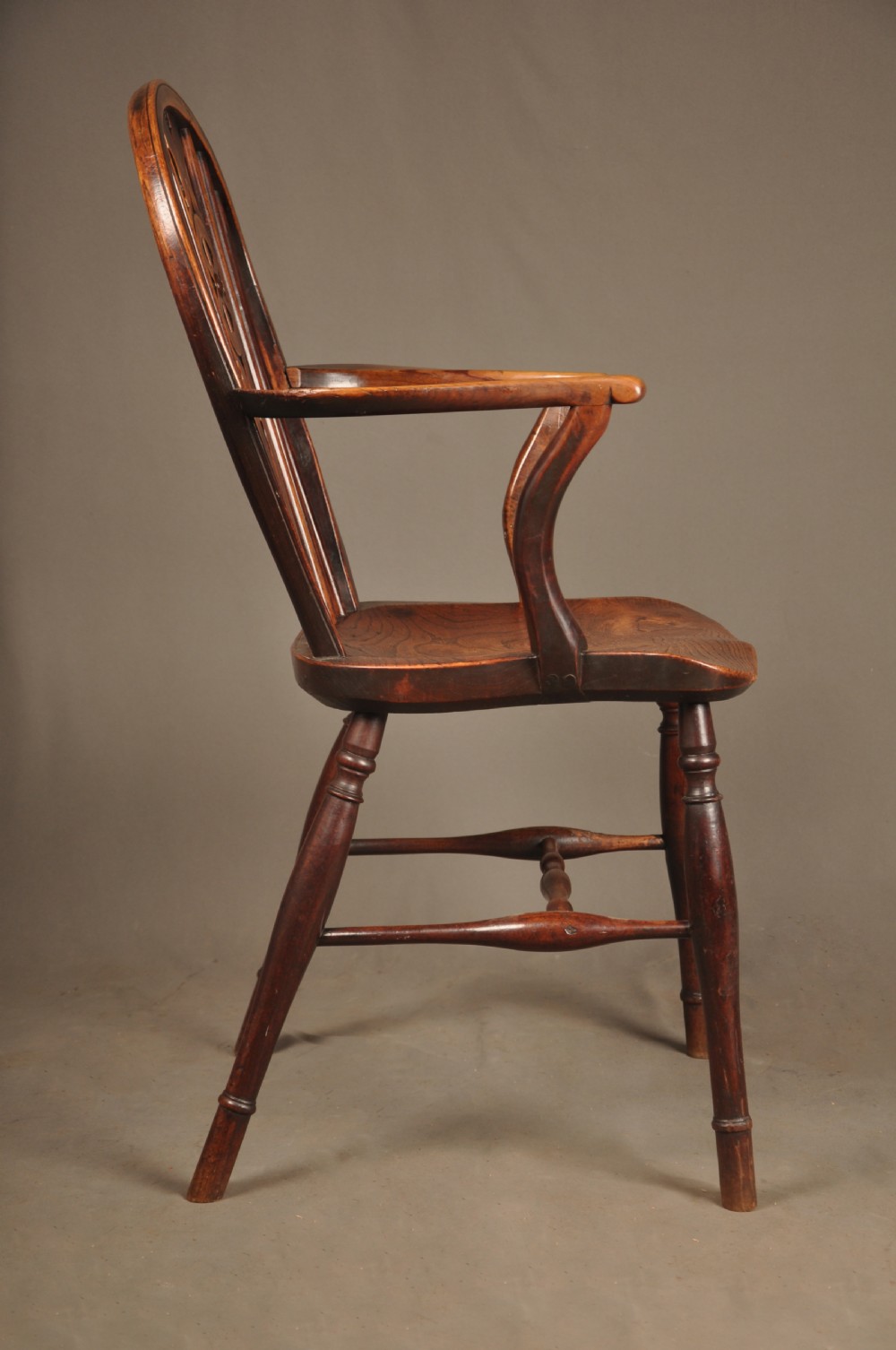 A pair of late 18th-century elm wheelback Windsor armchairs featuring curved backrests with pierced wheel splats, shaped seats, turned legs, and H-stretchers. View IV