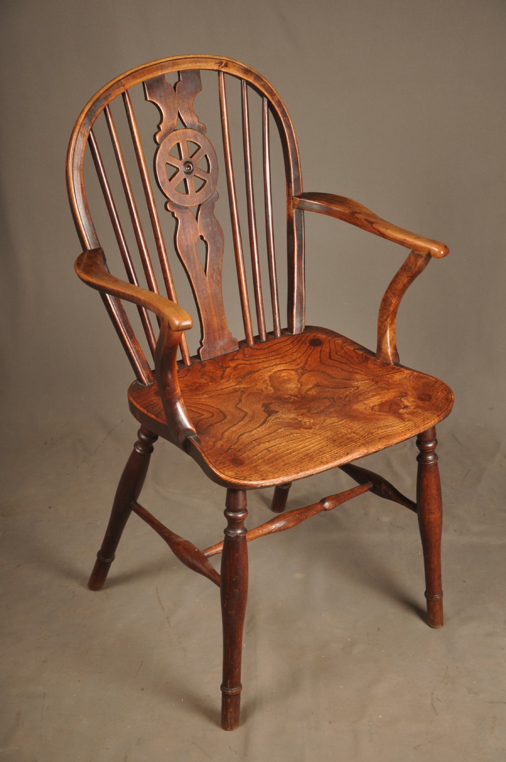 A pair of late 18th-century elm wheelback Windsor armchairs featuring curved backrests with pierced wheel splats, shaped seats, turned legs, and H-stretchers. View V