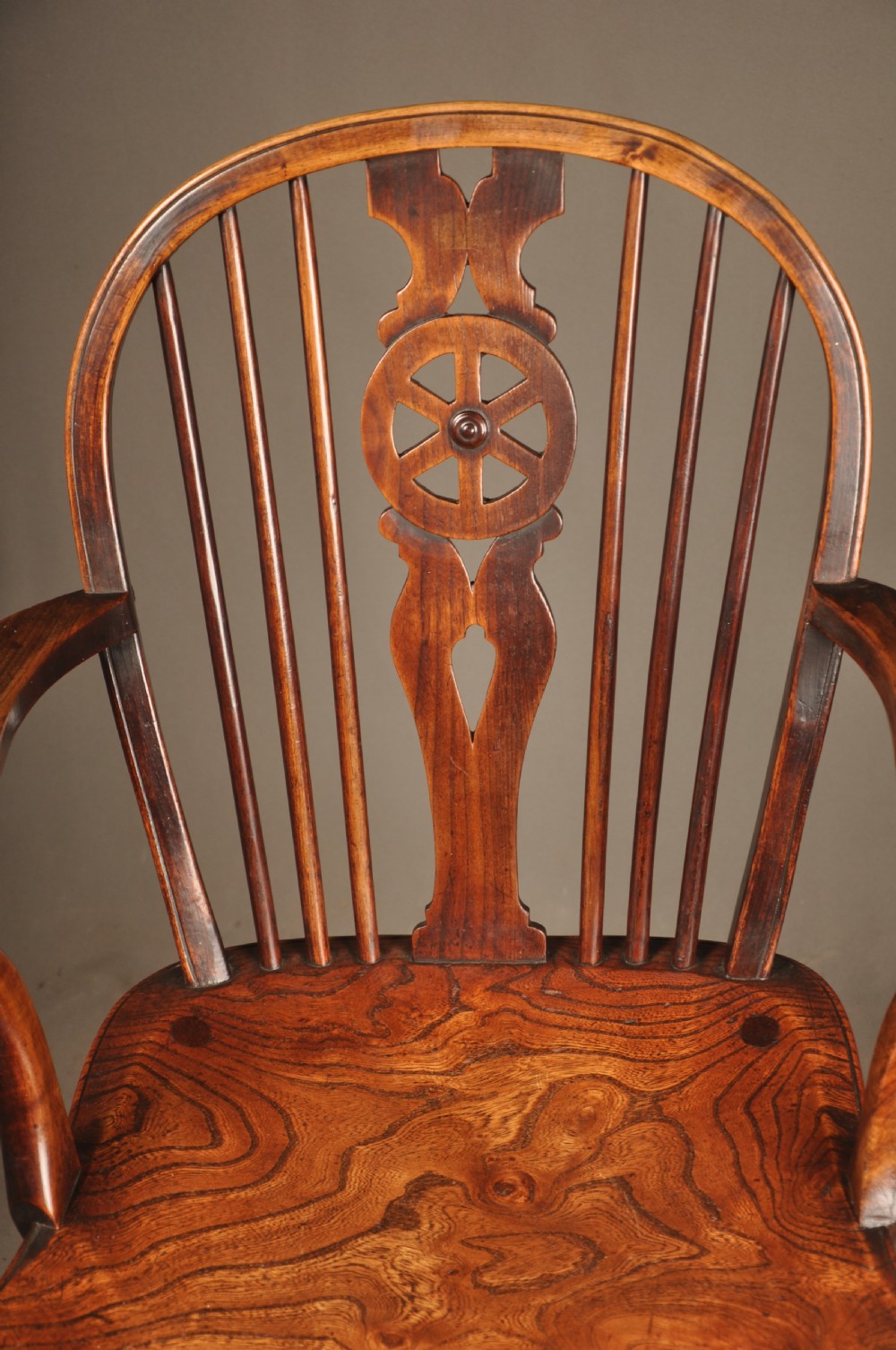 A pair of late 18th-century elm wheelback Windsor armchairs featuring curved backrests with pierced wheel splats, shaped seats, turned legs, and H-stretchers. View VII