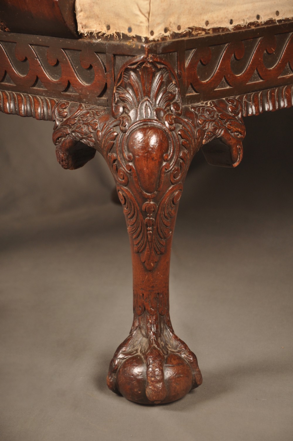 A 19th-century carved mahogany library armchair in calico lining, featuring cabriole legs with claw and ball feet and scrolled armrests. View VI