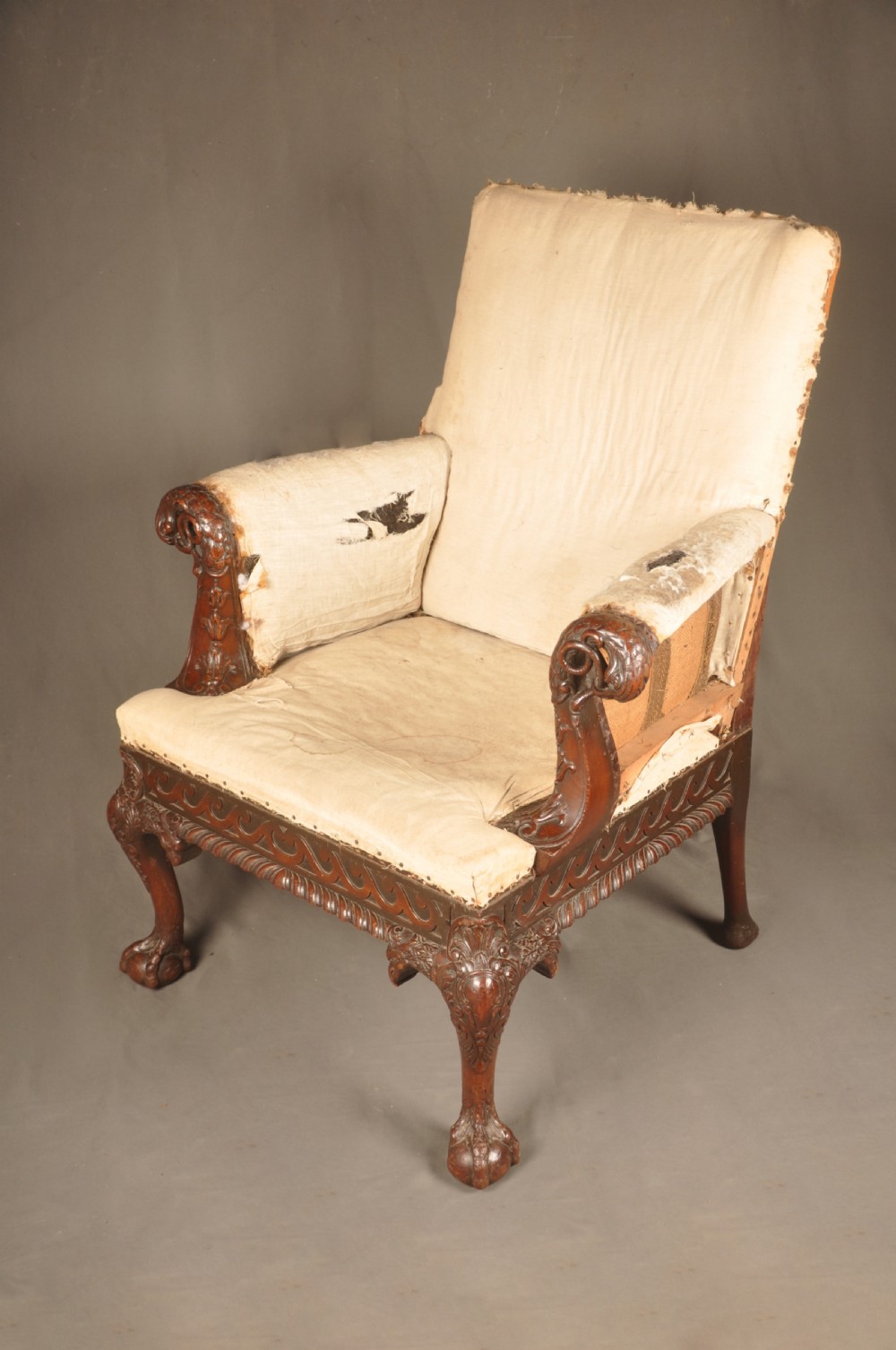 A 19th-century carved mahogany library armchair in calico lining, featuring cabriole legs with claw and ball feet and scrolled armrests. View VIII