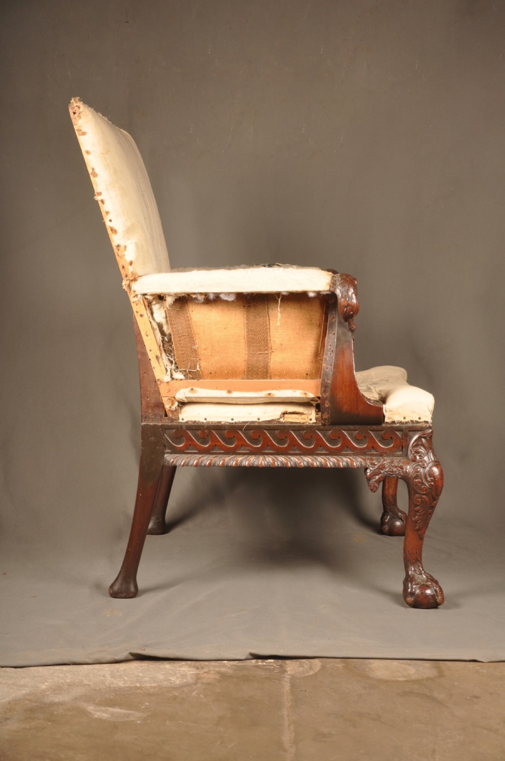 A 19th-century carved mahogany library armchair in calico lining, featuring cabriole legs with claw and ball feet and scrolled armrests. View IX