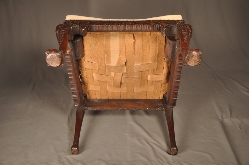 A 19th-century carved mahogany library armchair in calico lining, featuring cabriole legs with claw and ball feet and scrolled armrests. View XII