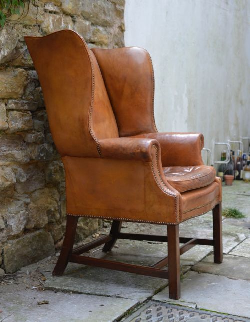 A LARGE GEORGE III STYLE TAN LEATHER WINGBACK ARMCHAIR - ADDITIONAL PHOTO 6