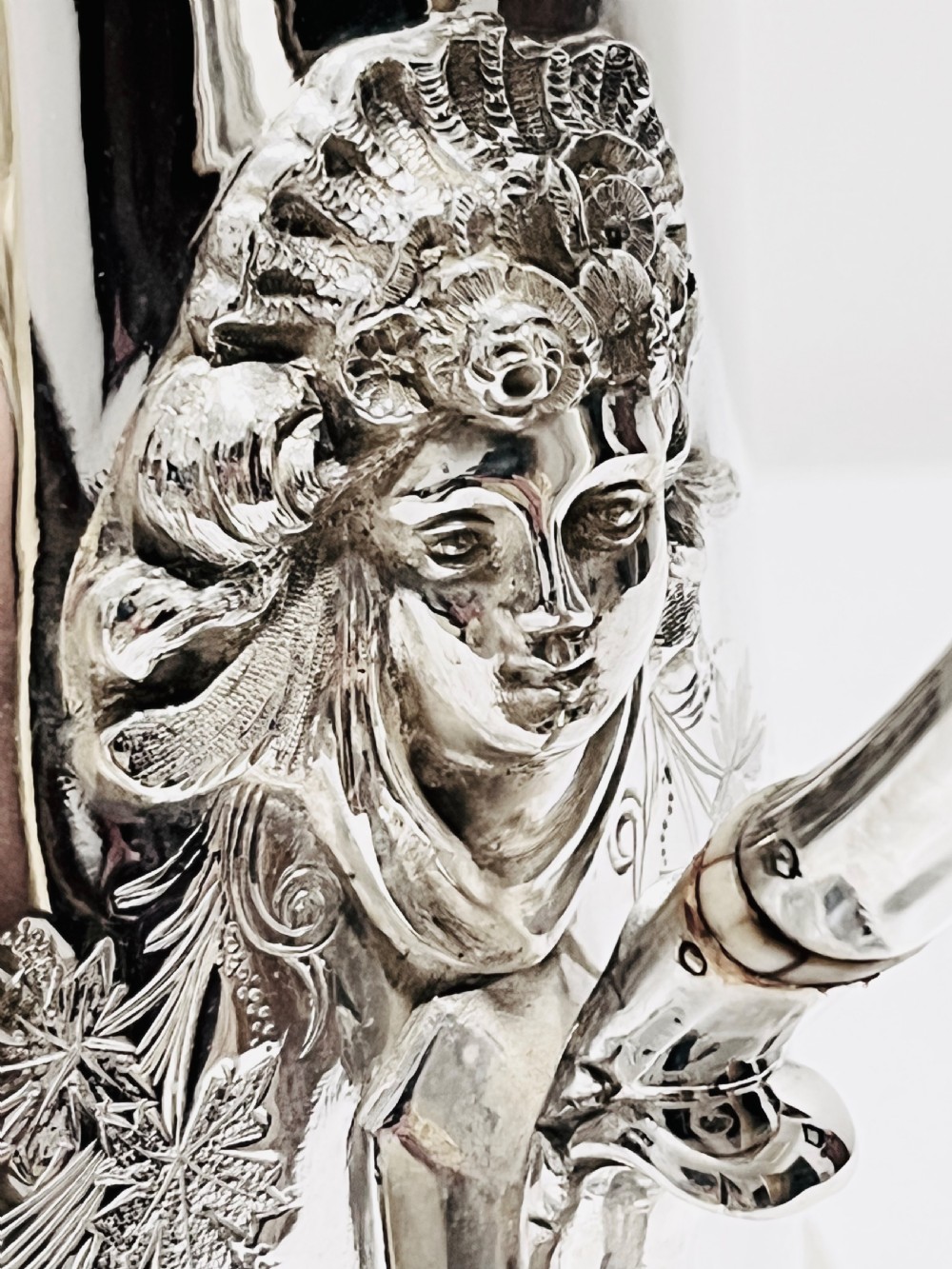 A Victorian lidded silver-plated jug featuring chased floral engraving, a scroll handle with insulating rings, and a hinged lid. View VIII