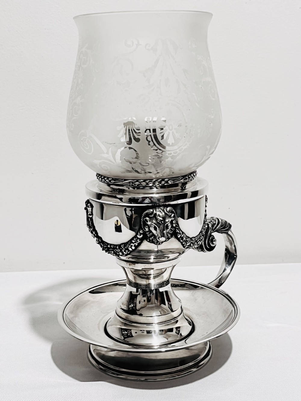 A late nineteenth-century German silver-plated chamberstick style table lamp with an etched frosted glass hurricane shade and a carved lion head motif. View VII