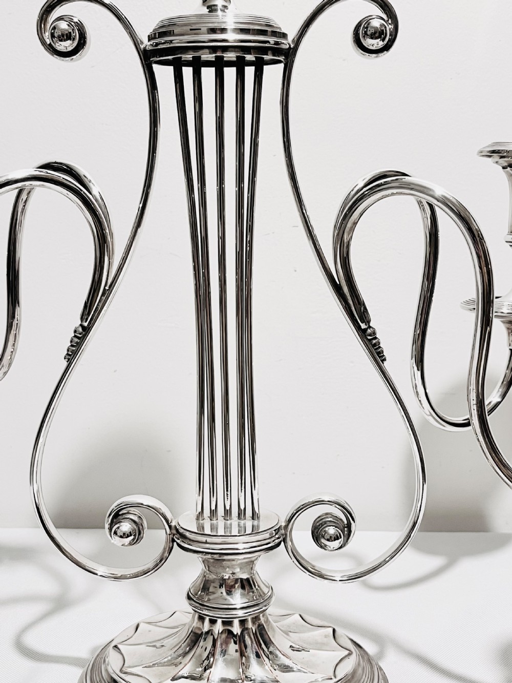 An antique silver-plated five-light candelabra featuring a central lyre-shaped stem with five scrolling branches terminating in circular candle nozzles. View II