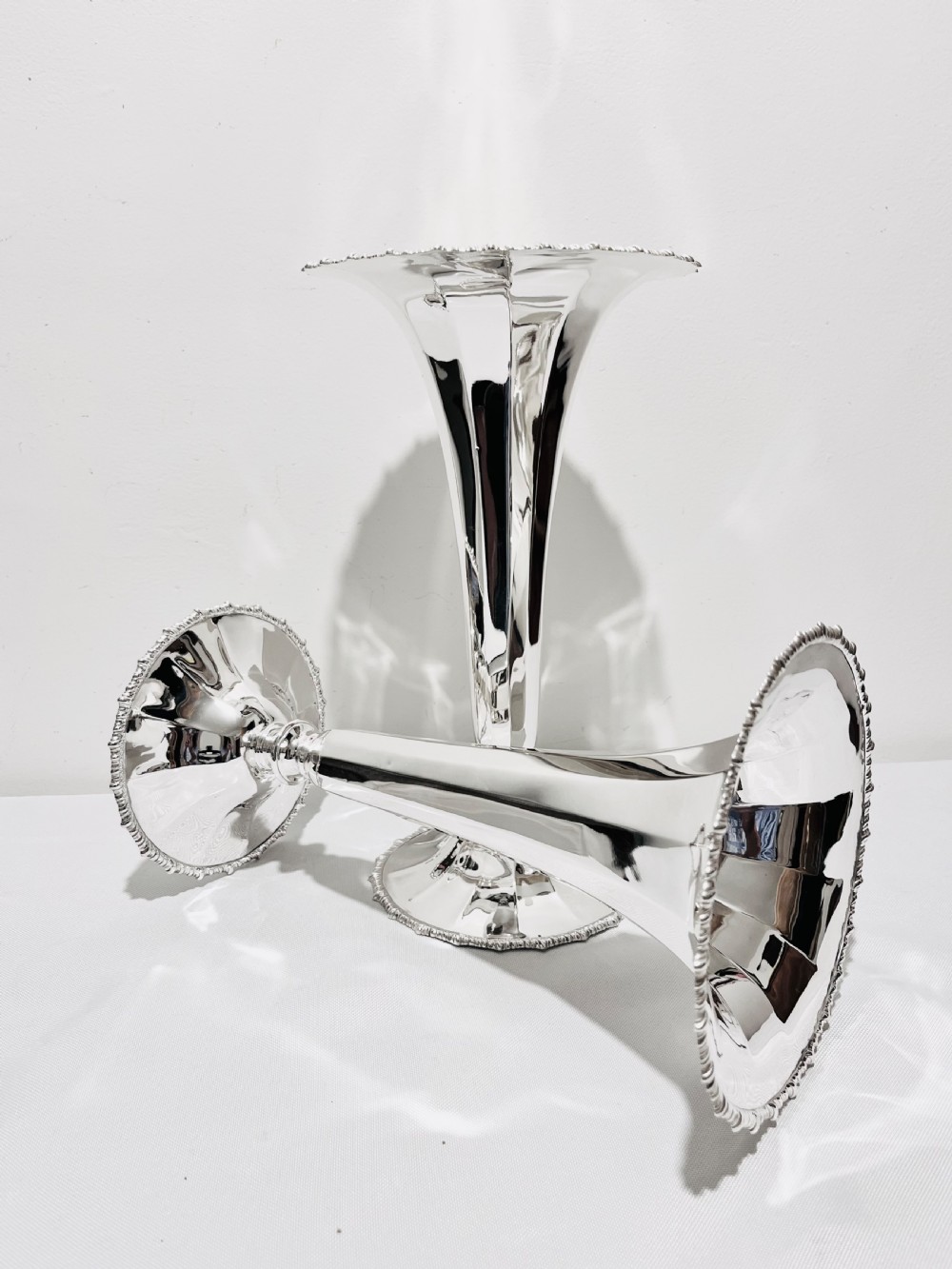 A pair of tall silver-plated trumpet vases featuring flared fluted rims, beaded border trims, and stepped circular bases. View V