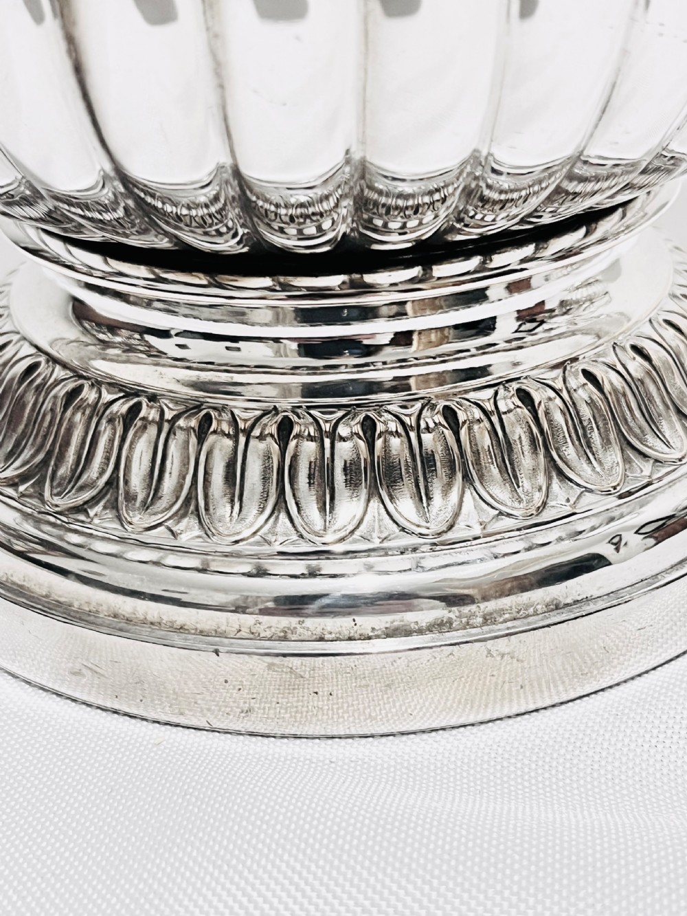 A pair of Regency silver-plated urn-shaped wine coolers featuring raised grapevine motifs, gadrooned rims, fluted bases, and twin side handles. View III
