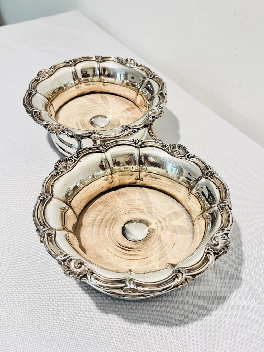 An antique Old Sheffield silver plate double wine decanter trolley with shell and scroll borders and turned wooden inserts. View III
