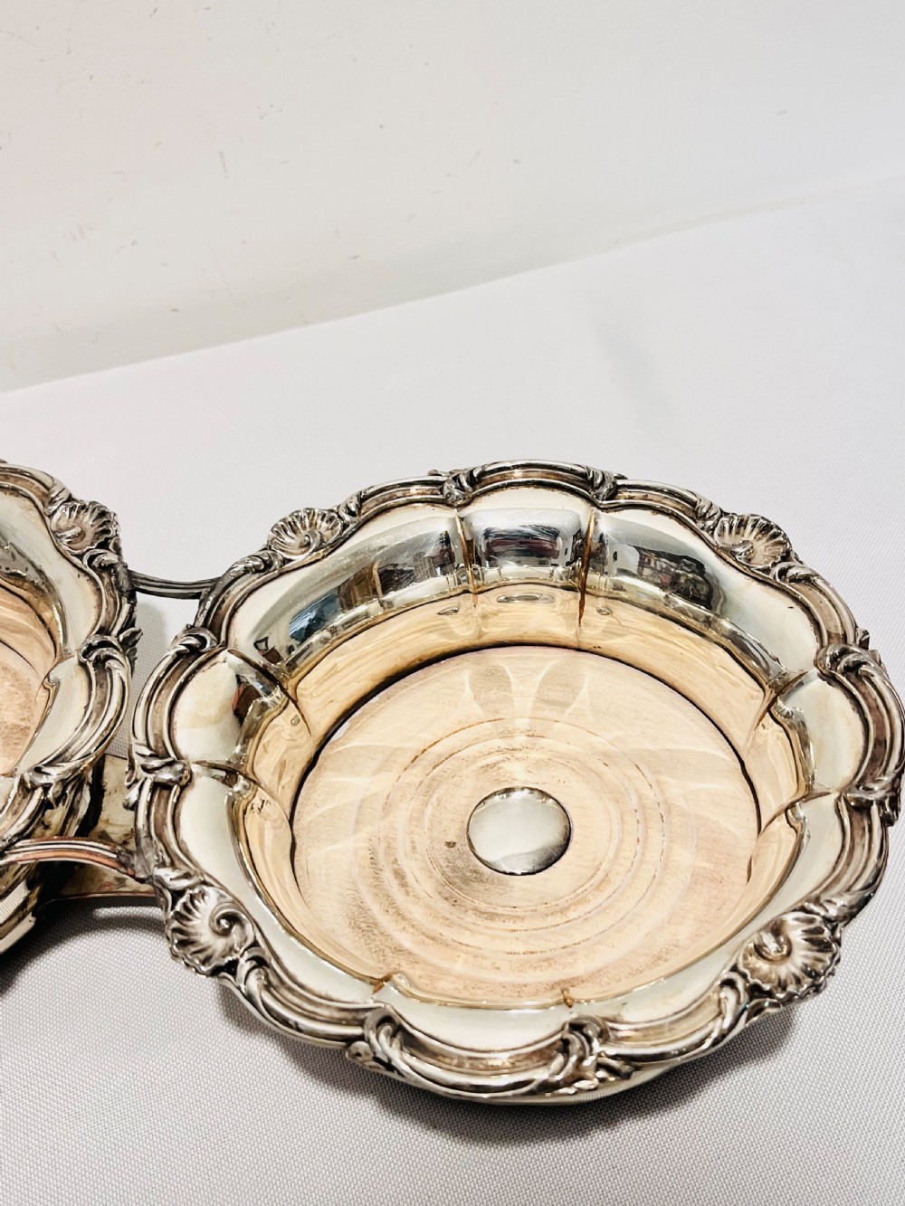 An antique Old Sheffield silver plate double wine decanter trolley with shell and scroll borders and turned wooden inserts. View IX