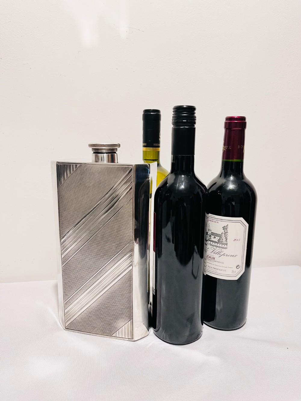 An Art Deco silver-plated giant spirit flask featuring geometric engine-turned pattern work and a cylindrical screw cap. View II