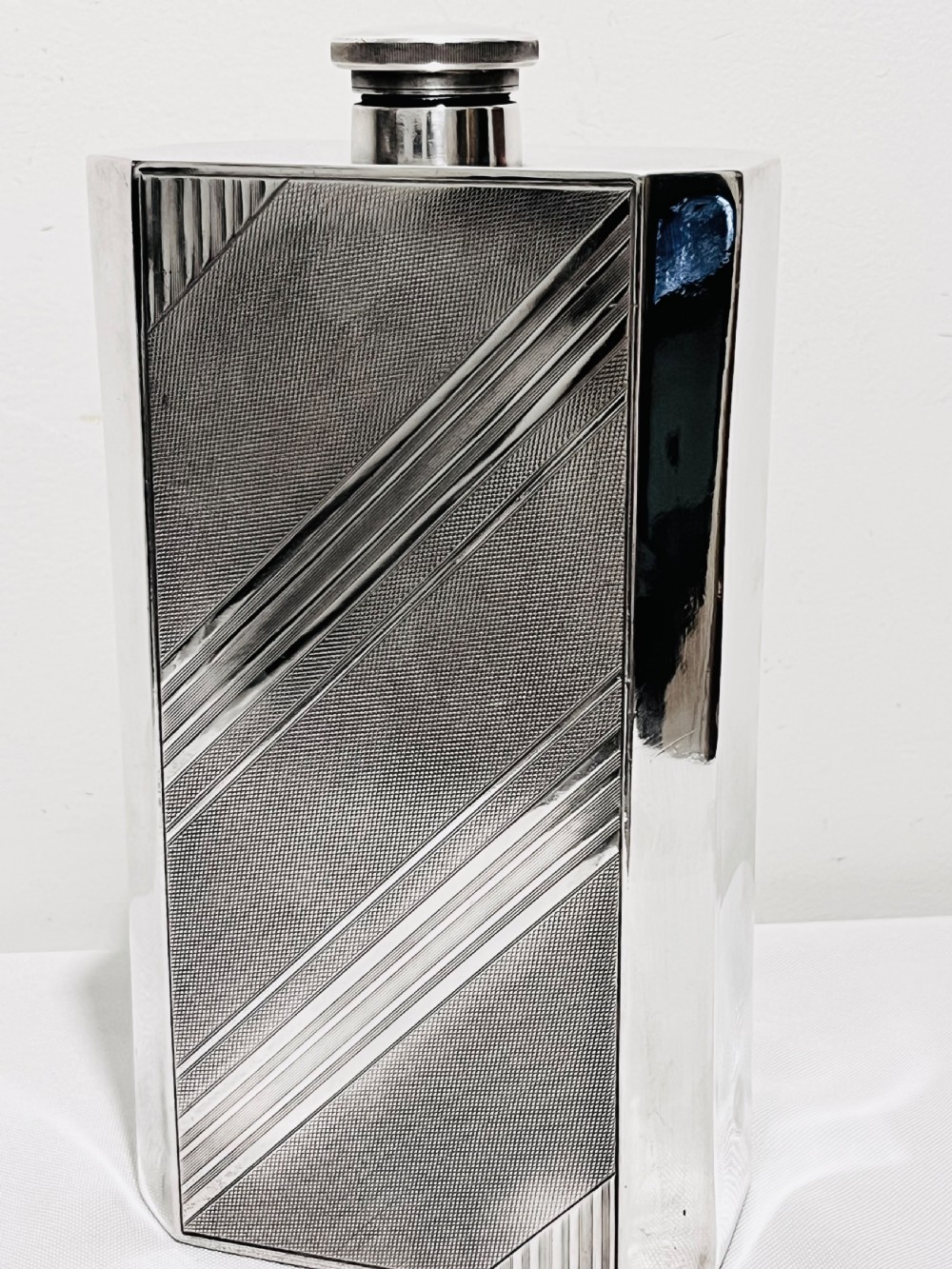 An Art Deco silver-plated giant spirit flask featuring geometric engine-turned pattern work and a cylindrical screw cap. View III