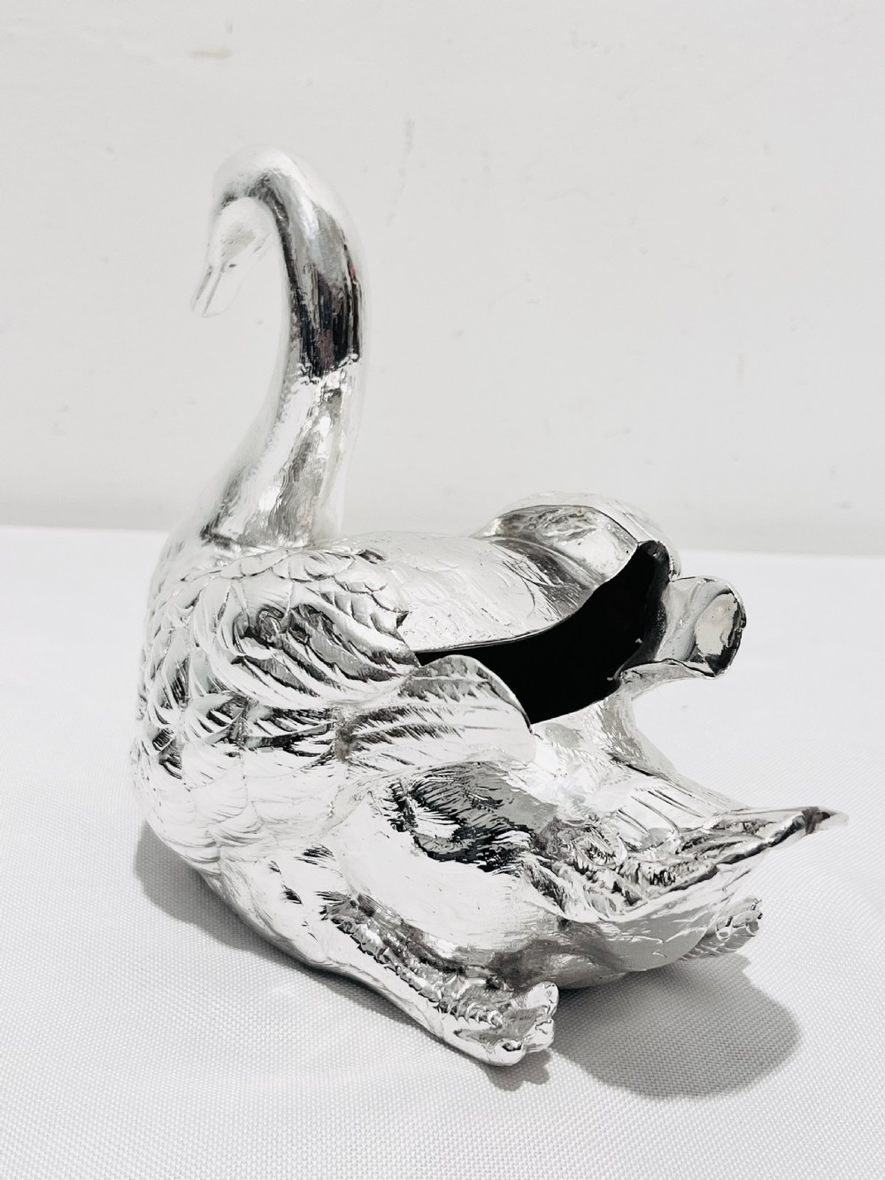 An antique silver-plated novelty spoon warmer cast in the detailed shape of a resting swan. View II