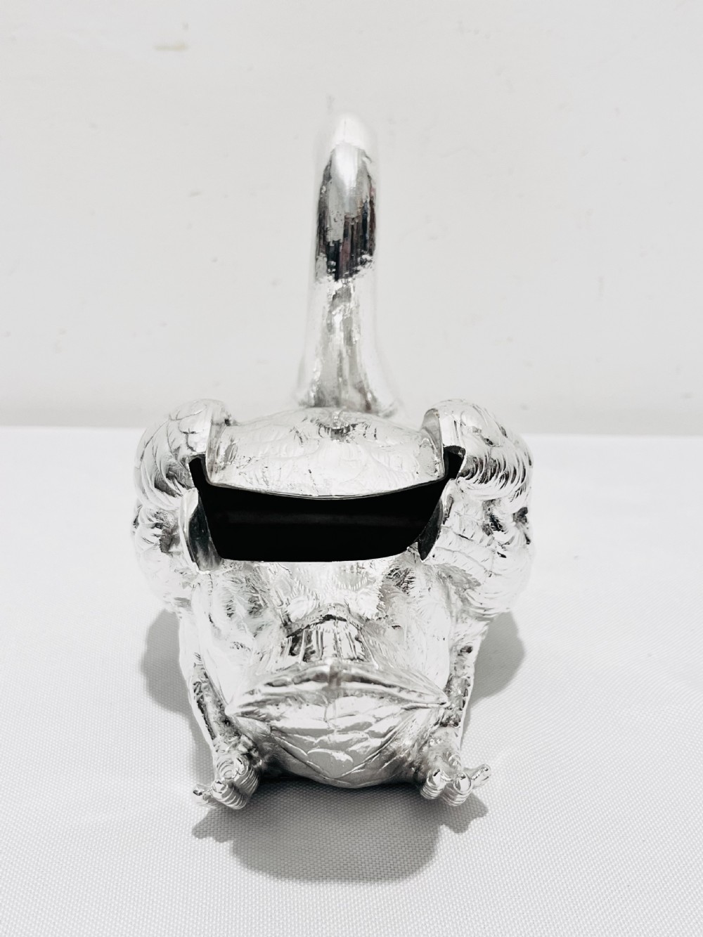 An antique silver-plated novelty spoon warmer cast in the detailed shape of a resting swan. View V