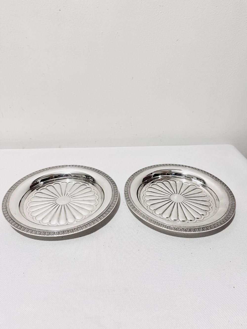 A pair of circular French silver-plated wine coasters featuring fluted central wells and detailed outer rims. View V