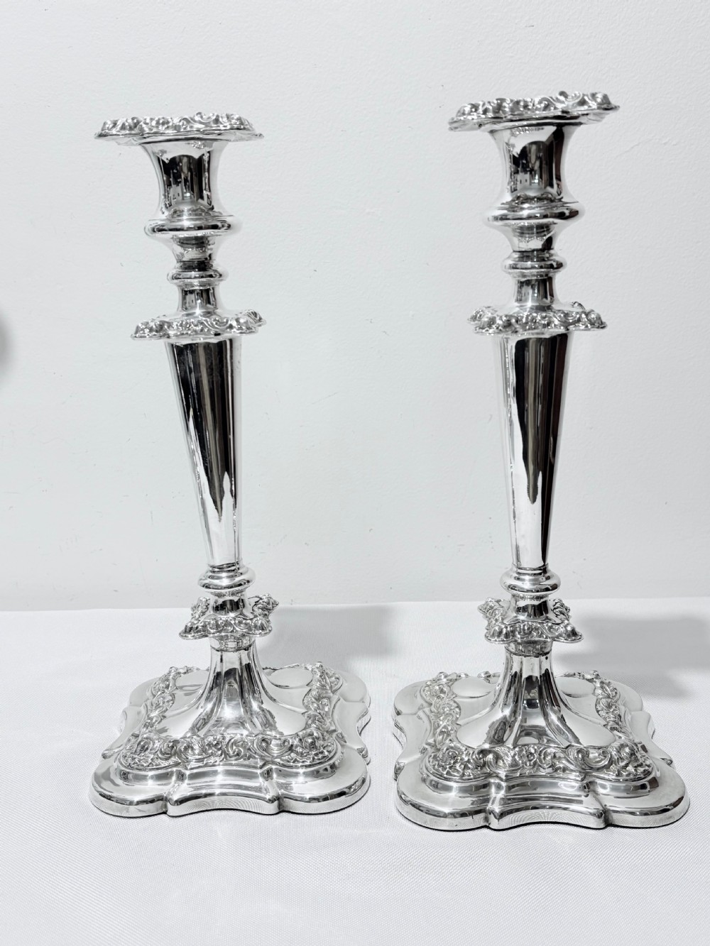 A three-piece antique silver-plated candelabra suite consisting of a central five-light branch candelabrum flanked by two matching single candlesticks. View VI