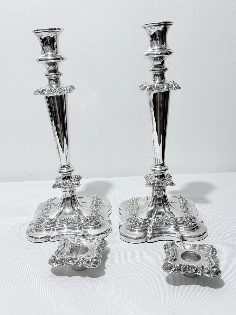 A three-piece antique silver-plated candelabra suite consisting of a central five-light branch candelabrum flanked by two matching single candlesticks. View VII