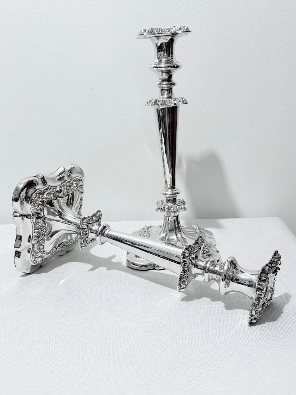 A three-piece antique silver-plated candelabra suite consisting of a central five-light branch candelabrum flanked by two matching single candlesticks. View VIII