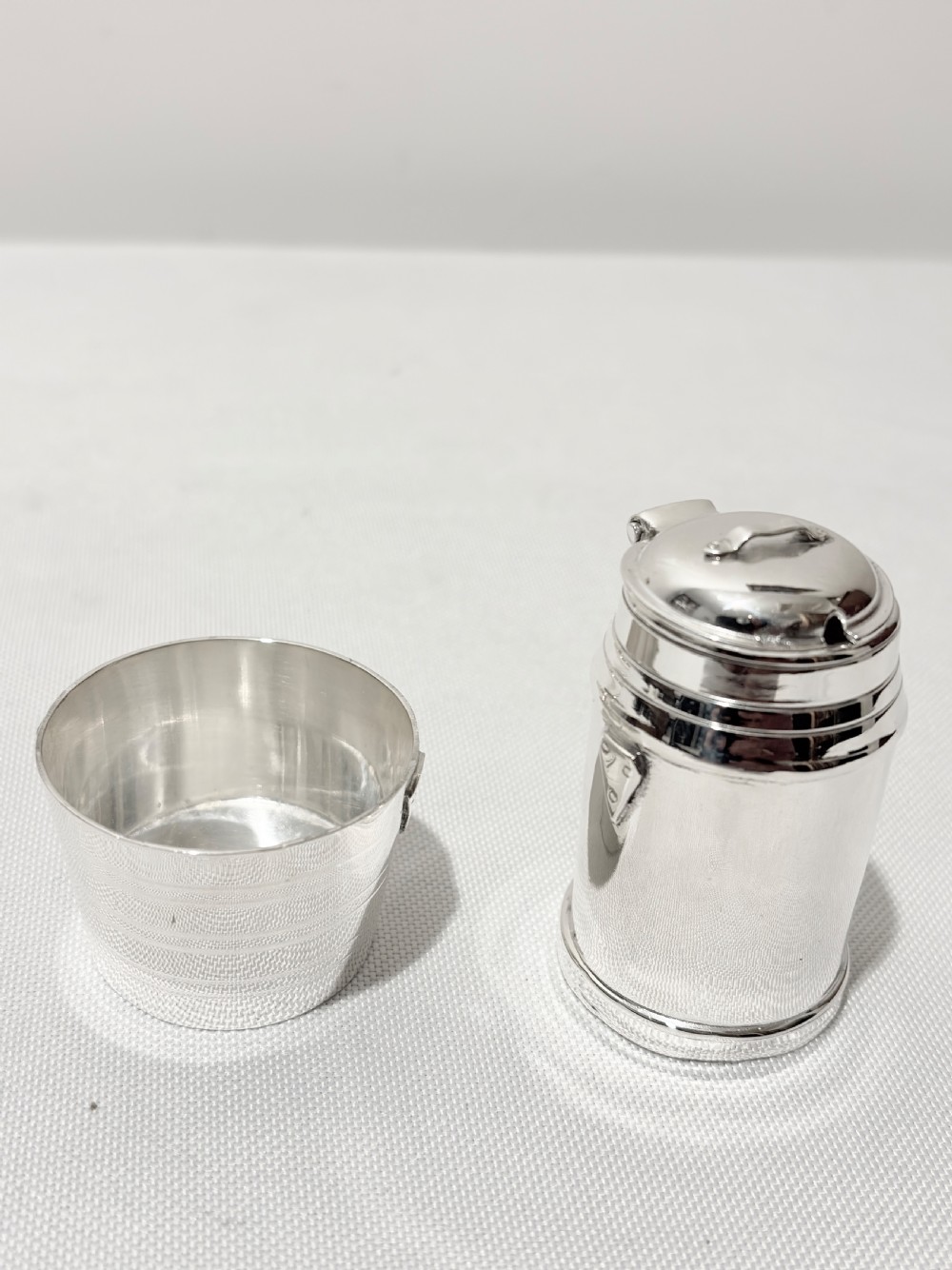 A Victorian silver-plated novelty cruet set featuring a central water pump pepper caster, a bucket salt cellar, and a milk churn mustard pot on a circular engraved tray. View V
