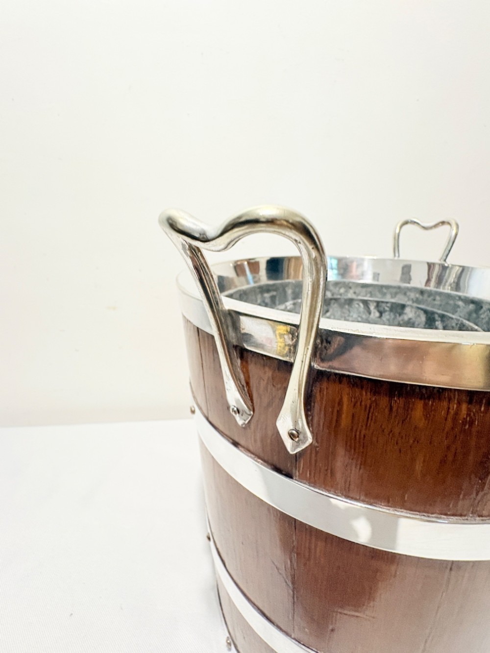 An antique coopered oak wine bucket featuring polished silver-plated bands, twin side handles, and a removable metal liner. View VI