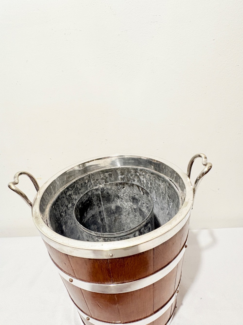 An antique coopered oak wine bucket featuring polished silver-plated bands, twin side handles, and a removable metal liner. View VIII