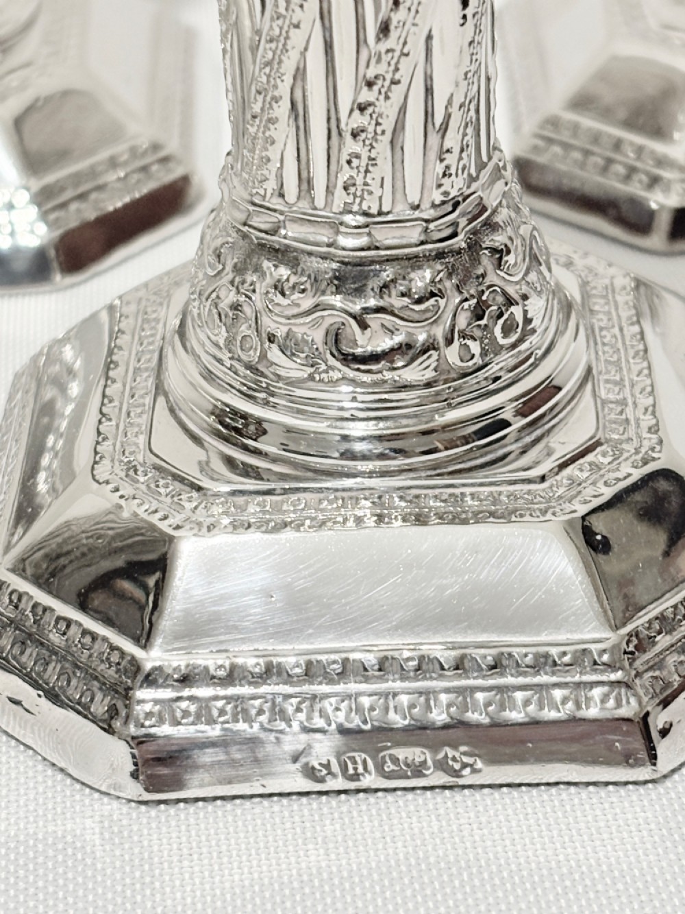 A set of four matching silver column candlesticks with spiral fluted stems and decorated octagonal bases. View III