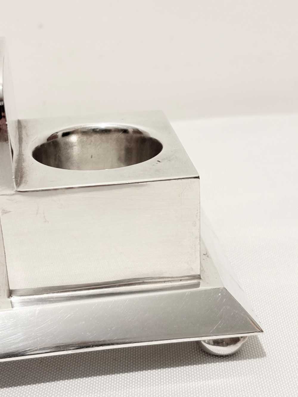 A Victorian silver-plated toast rack with radiator-style dividers flanked by two integrated egg holders on a rectangular base with ball feet. View IV
