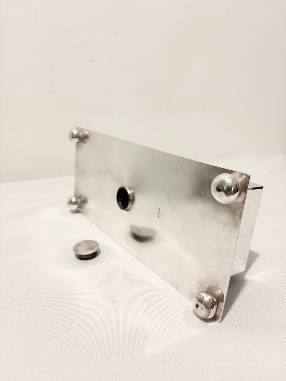 A Victorian silver-plated toast rack with radiator-style dividers flanked by two integrated egg holders on a rectangular base with ball feet. View VIII