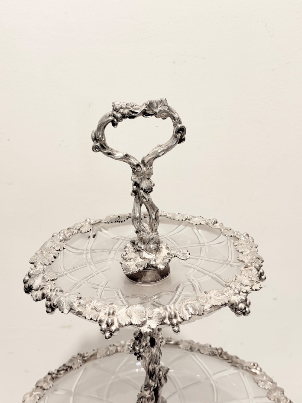 A Victorian silver-plated two-tiered epergne centerpiece featuring grapevine motifs and two cut glass trays. View II