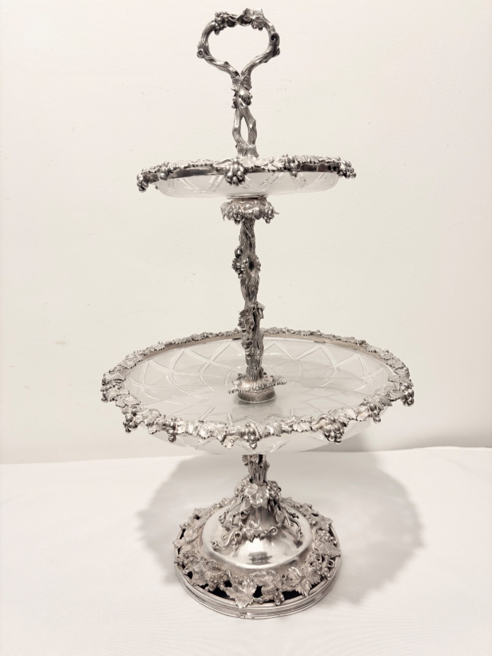 A Victorian silver-plated two-tiered epergne centerpiece featuring grapevine motifs and two cut glass trays. View VII