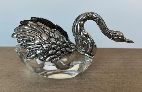 A clear crystal swan salt cellar featuring articulated sterling silver wings and a sculpted silver neck. View II