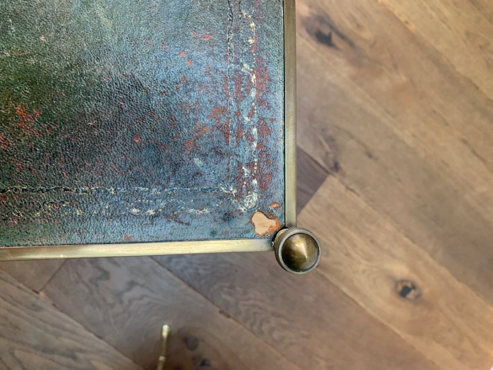 A two-tier brass occasional table featuring faux-bamboo legs, corner finials, and green leather surfaces with gold leaf tooling. View X