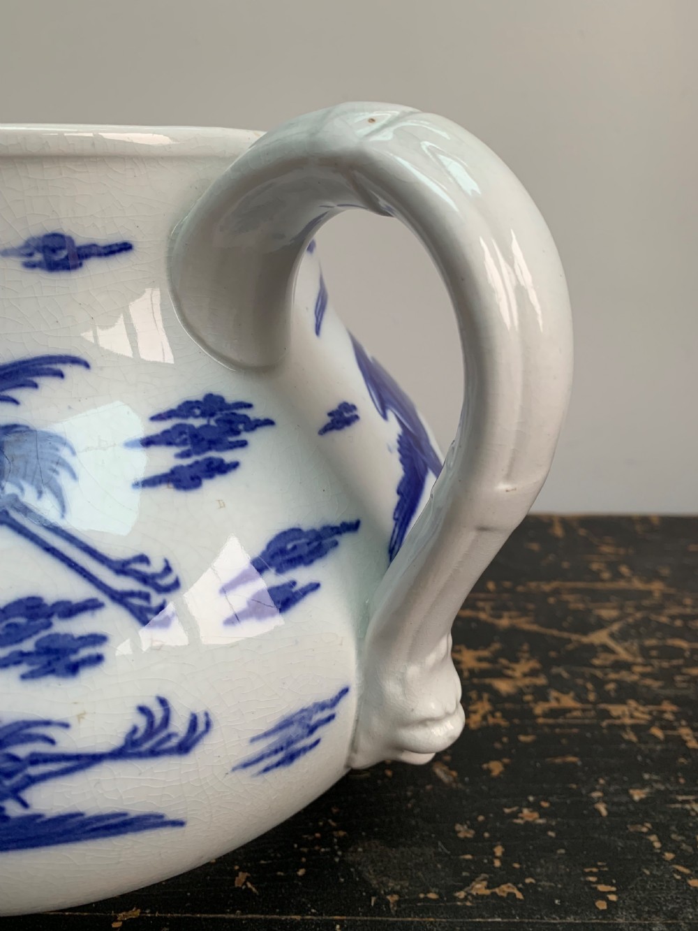 A bulbous white ceramic jug featuring transfer-printed blue flying cranes, a crackle glaze finish, and a moulded handle. View II