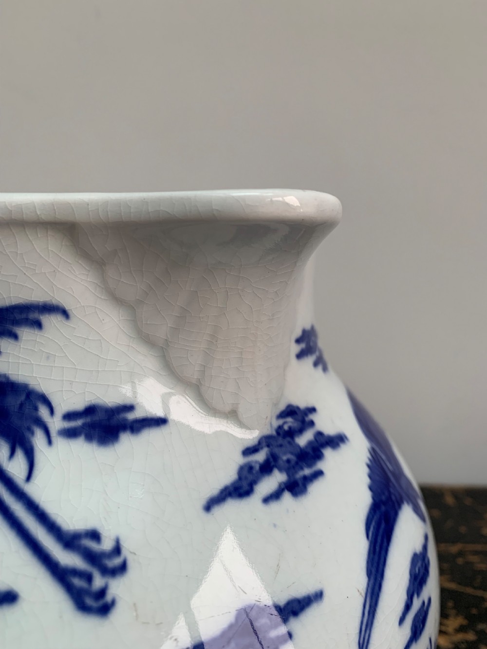 A bulbous white ceramic jug featuring transfer-printed blue flying cranes, a crackle glaze finish, and a moulded handle. View VI
