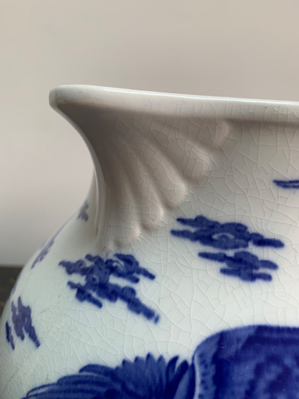 A bulbous white ceramic jug featuring transfer-printed blue flying cranes, a crackle glaze finish, and a moulded handle. View VII