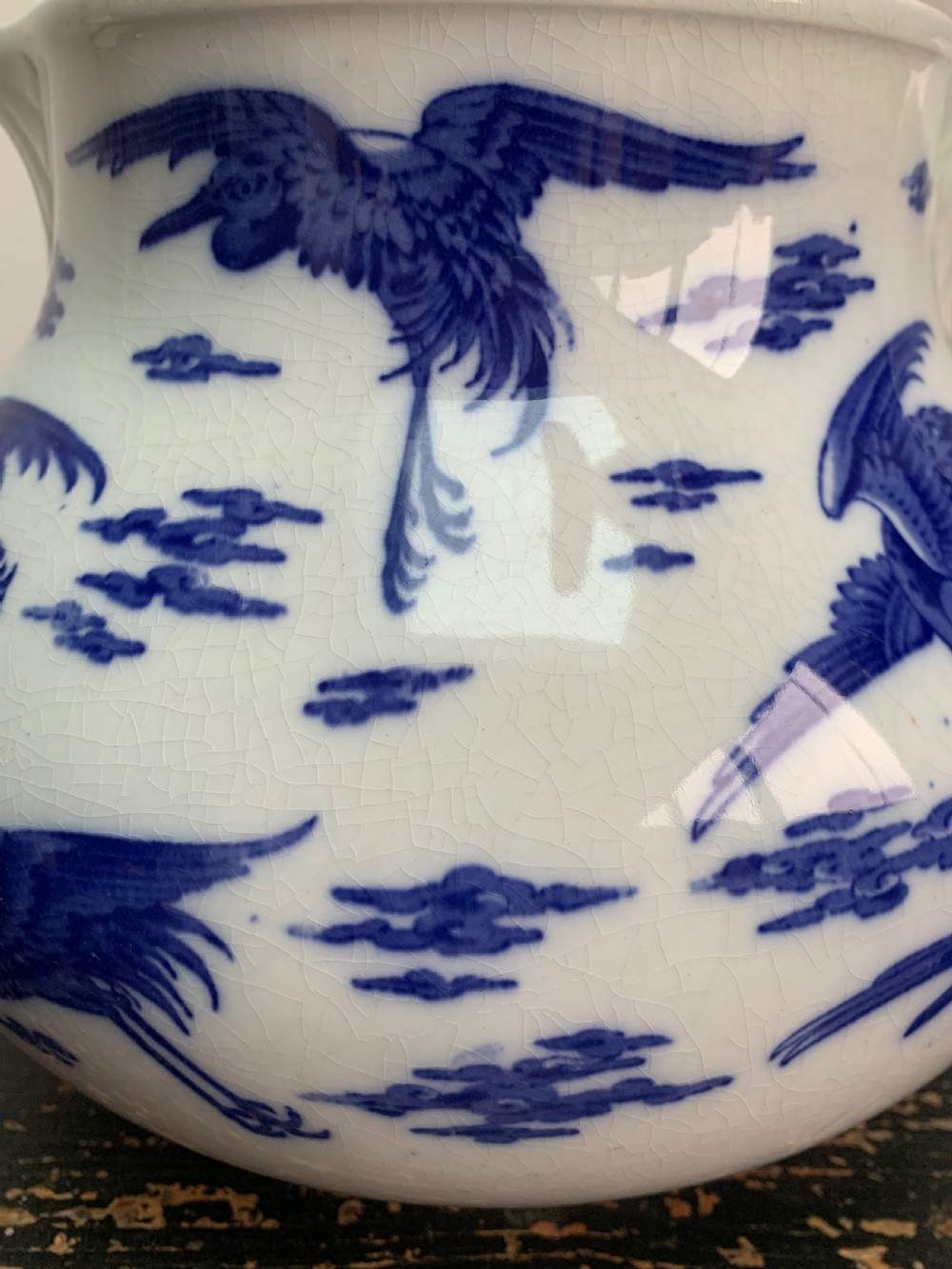 A bulbous white ceramic jug featuring transfer-printed blue flying cranes, a crackle glaze finish, and a moulded handle. View IX