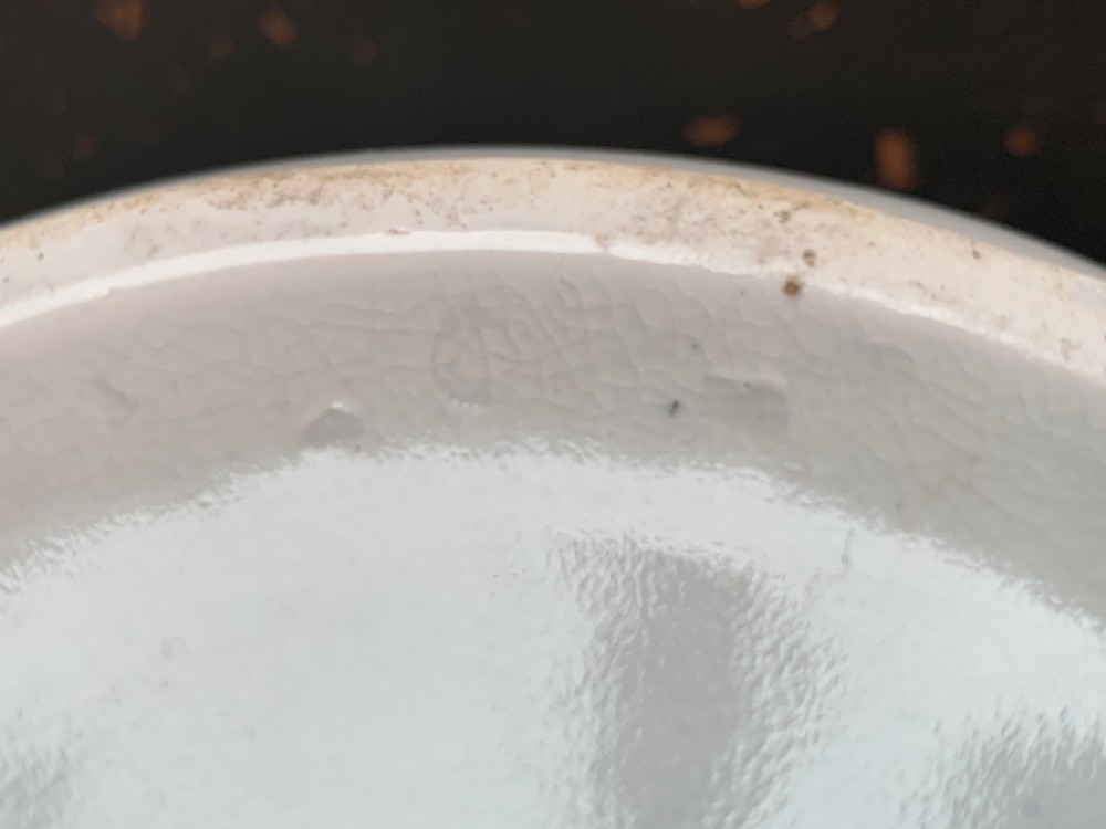 A bulbous white ceramic jug featuring transfer-printed blue flying cranes, a crackle glaze finish, and a moulded handle. View X