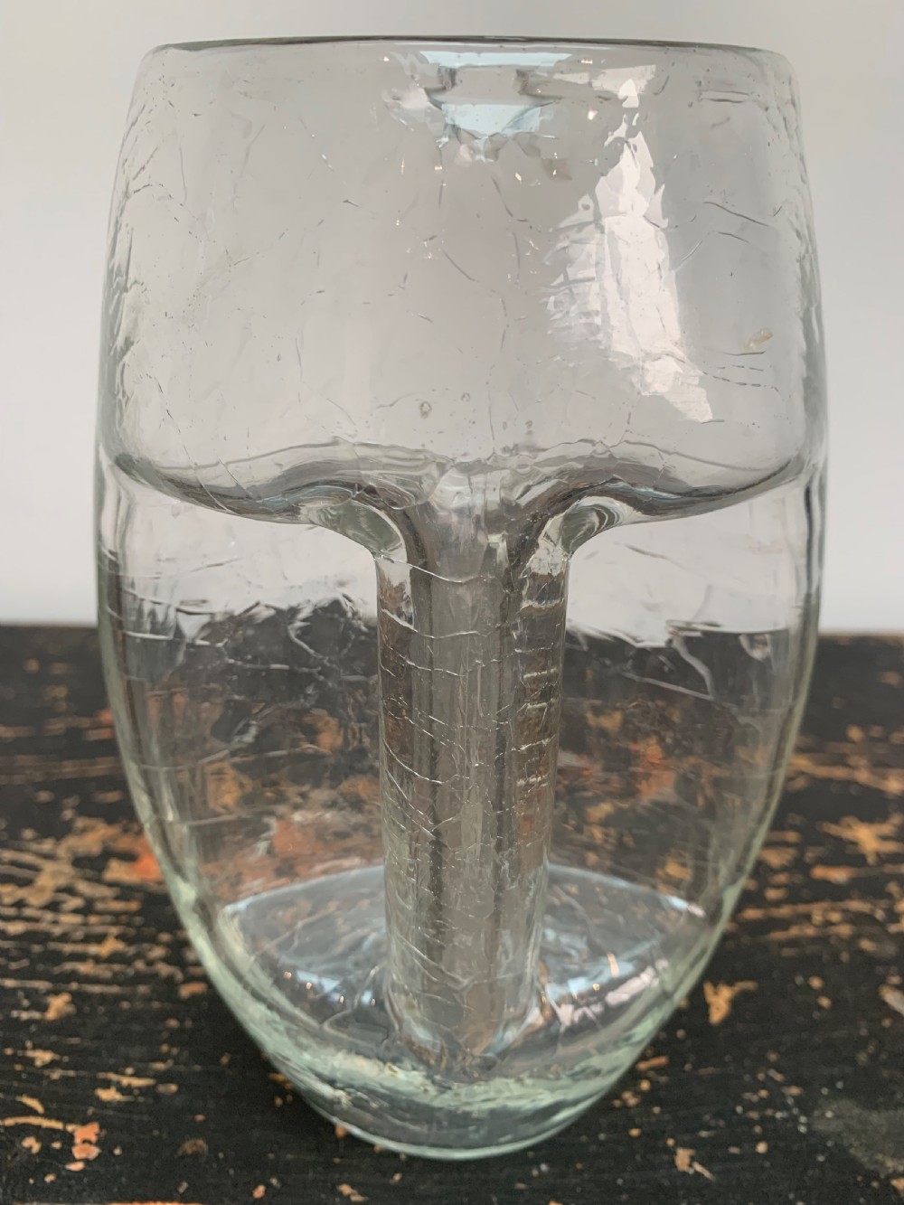 A clear blown glass jug featuring an all-over crackle finish and an integrated vertical handle. View II