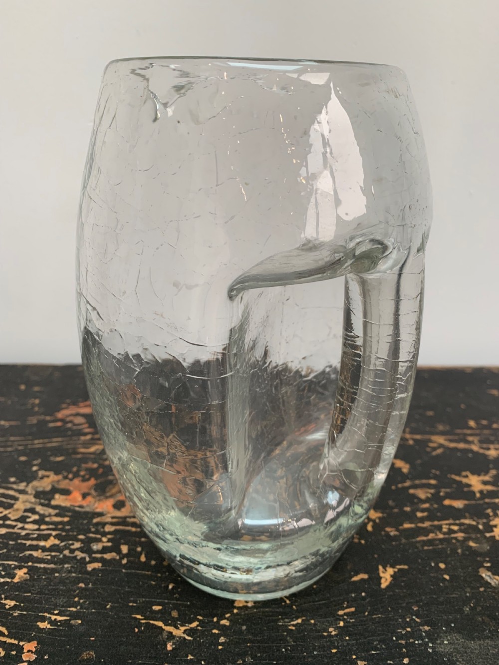 A clear blown glass jug featuring an all-over crackle finish and an integrated vertical handle. View III