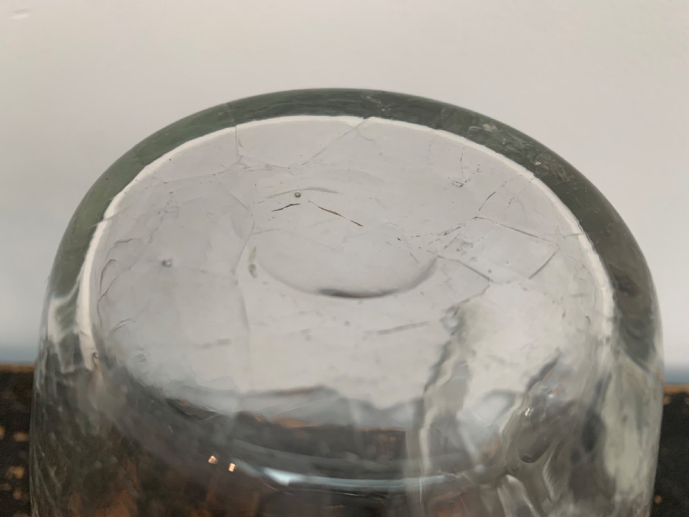 A clear blown glass jug featuring an all-over crackle finish and an integrated vertical handle. View X