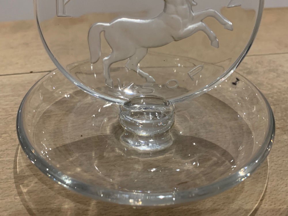 A clear glass Art Deco circular ashtray featuring an upright circular medallion with a frosted relief depicting a centaur holding a javelin above the lettering REMY MARTIN V.S.O.P. View VI