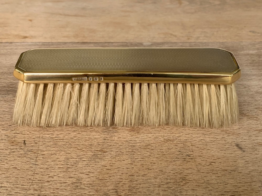 An Art Deco engine-turned silver-gilt rectangular clothes brush by Asprey with dense light-coloured natural bristles. View II
