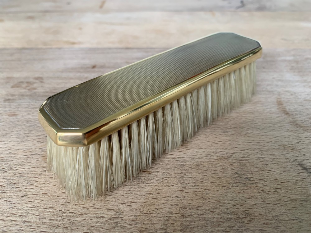 An Art Deco engine-turned silver-gilt rectangular clothes brush by Asprey with dense light-coloured natural bristles. View V