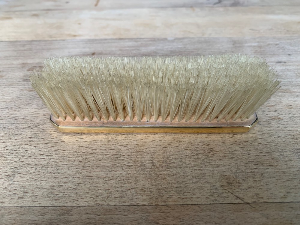 An Art Deco engine-turned silver-gilt rectangular clothes brush by Asprey with dense light-coloured natural bristles. View VI