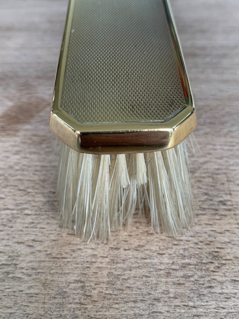An Art Deco engine-turned silver-gilt rectangular clothes brush by Asprey with dense light-coloured natural bristles. View VIII