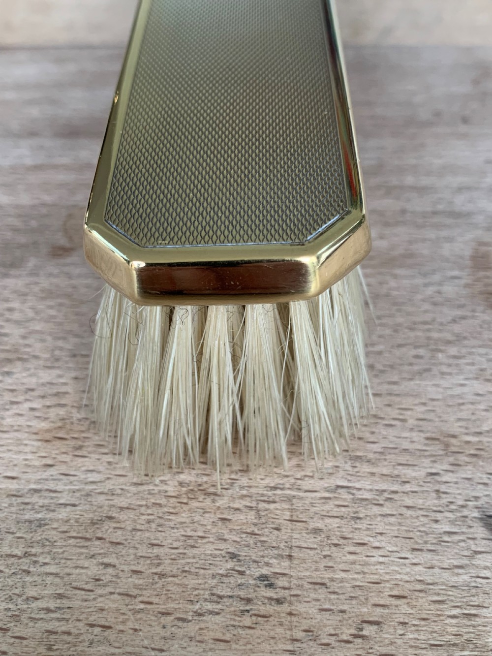 An Art Deco engine-turned silver-gilt rectangular clothes brush by Asprey with dense light-coloured natural bristles. View IX