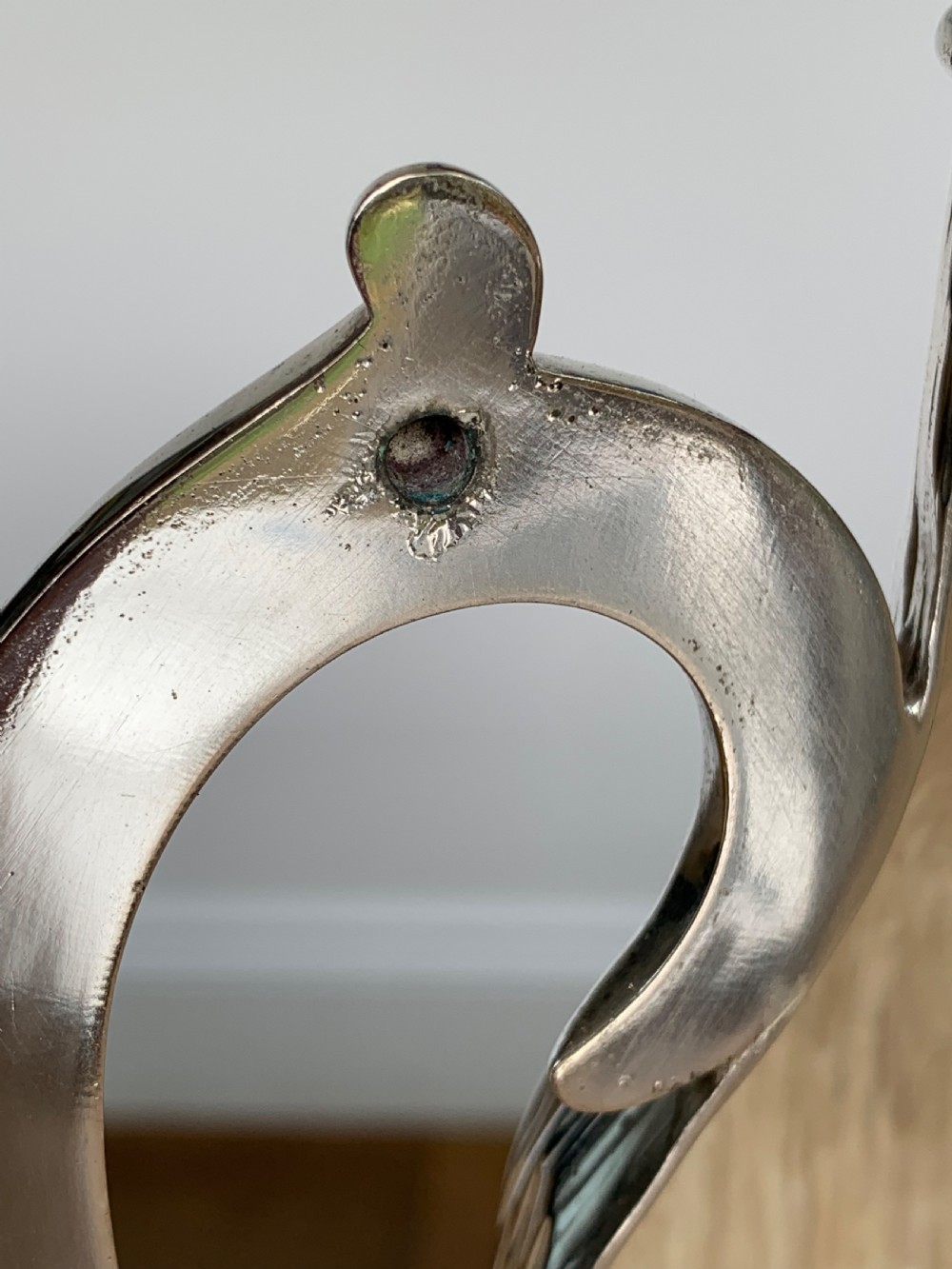 A 19th-century silver-plated wine bottle holder featuring a textured bark effect finish and a long sweeping curved handle. View XI
