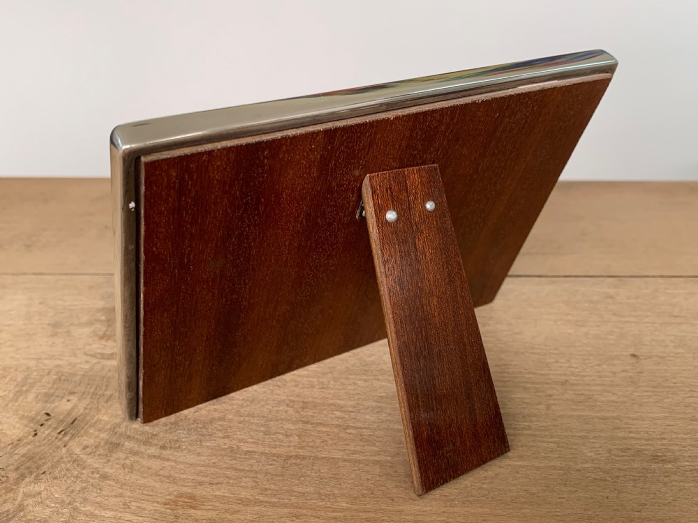 A rectangular sterling silver twin photo frame with linear engine-turned texturing and two oval apertures. View VI