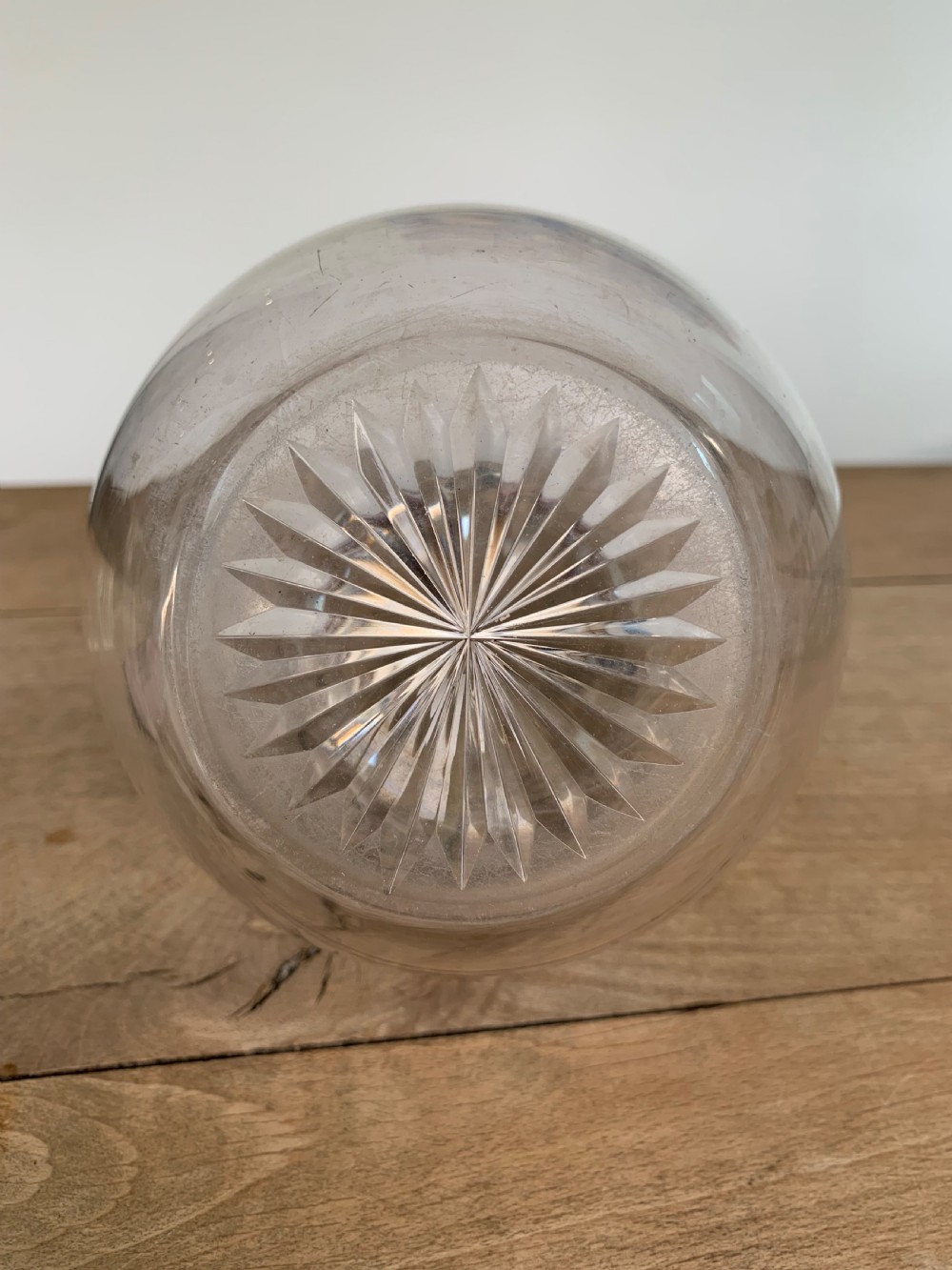 A clear spherical glass claret jug featuring a silver-plated collar, flat hinged cap, angular handle, and a cut starburst pattern on the base. View VII